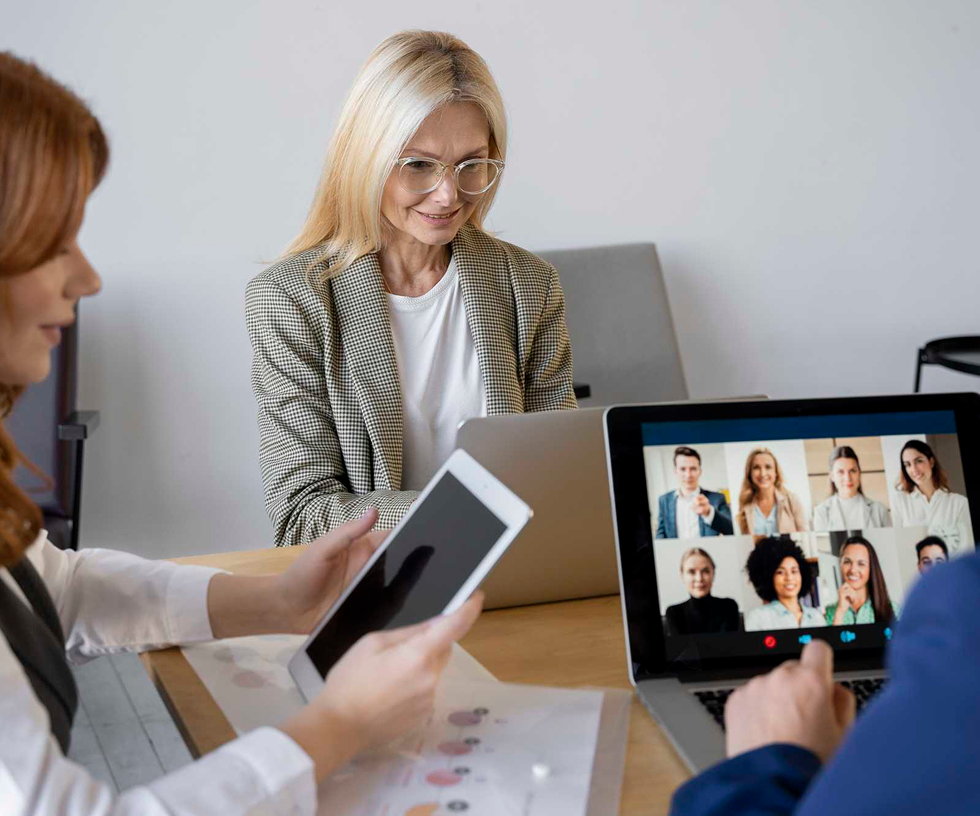 Team members using tablets during an all-hands meeting