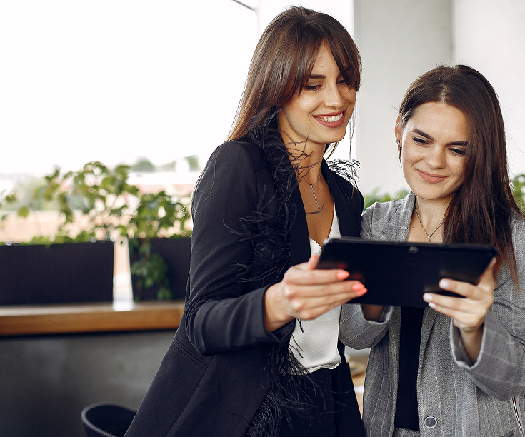 Two women using a tablet during a webinar
